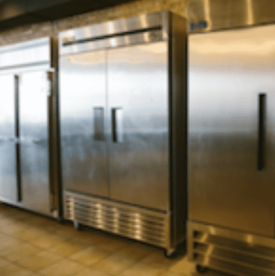 A row of refrigerators in a commercial kitchen.