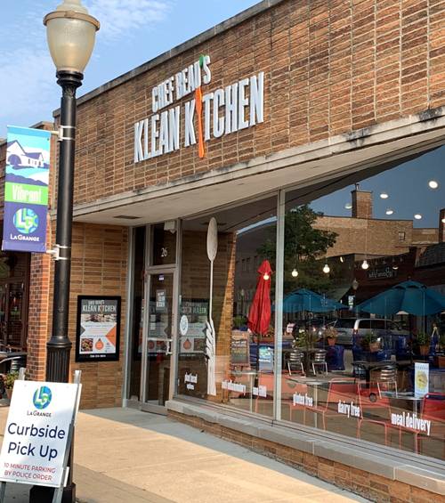 A clean kitchen restaurant is shown on the sidewalk.